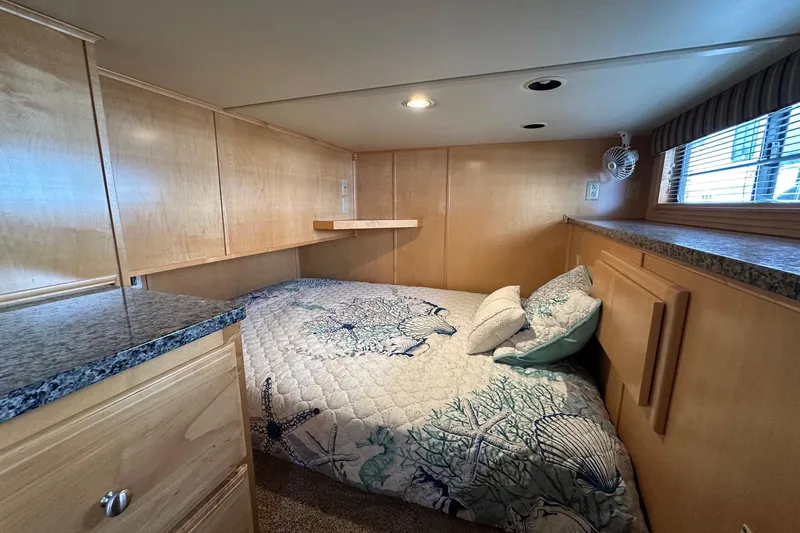 Slide: The Image of Cozy bedroom in 2005 Sumerset 16x68 houseboat with nautical-themed bedding and wood paneling. - 8