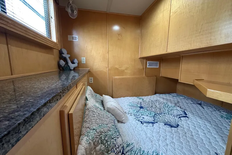 Slide: The Image of Cozy bedroom in 2005 Sumerset 16x68 houseboat with wooden cabinetry and ocean-themed bedding. - 9