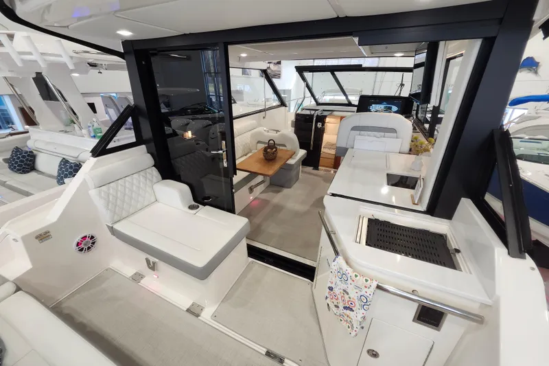 Slide: The Image of 2025 Regal 36 XO yacht interior with modern seating, kitchenette, and helm station. - 13