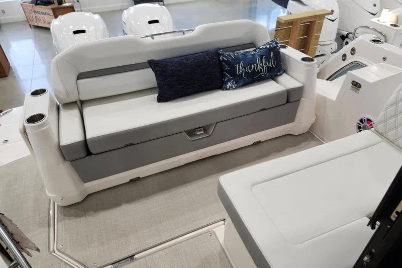 Slide: The Image of 2025 Regal 36 XO boat interior with cushioned seating and decorative pillows. - 17