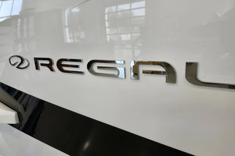 Slide: The Image of 2025 Regal 36 XO boat logo on sleek white surface. - 6