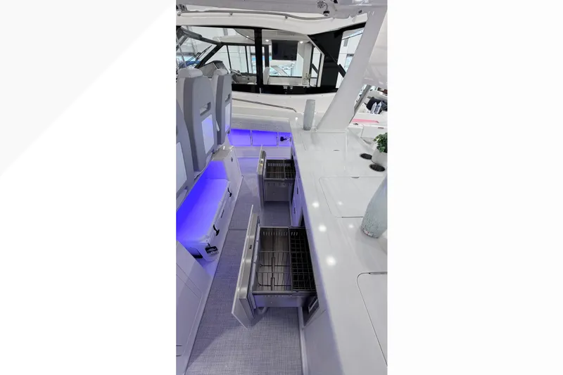 Slide: The Image of Open storage compartment on 2026 Regal 38 SAV boat with waste disposal instructions. - 10