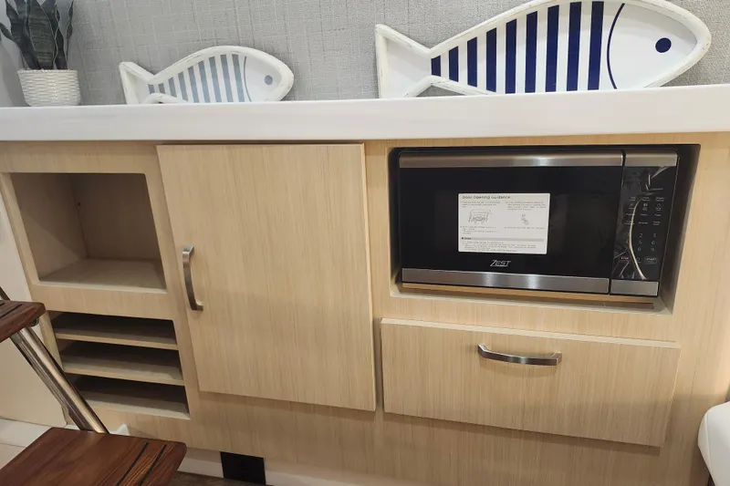 Slide: The Image of Modern kitchen area in 2026 Regal 38 SAV boat with microwave and decorative fish plates. - 27