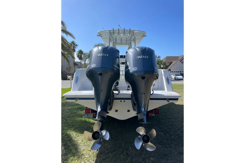 Slide: The Image of 2008 Contender 27 Tournament boat on trailer, parked on grass under palm trees. - 5