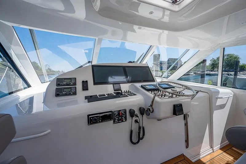 Slide: The Image of Helm of 2012 Cabo 44 HTX yacht with modern navigation equipment and panoramic windows. - 20