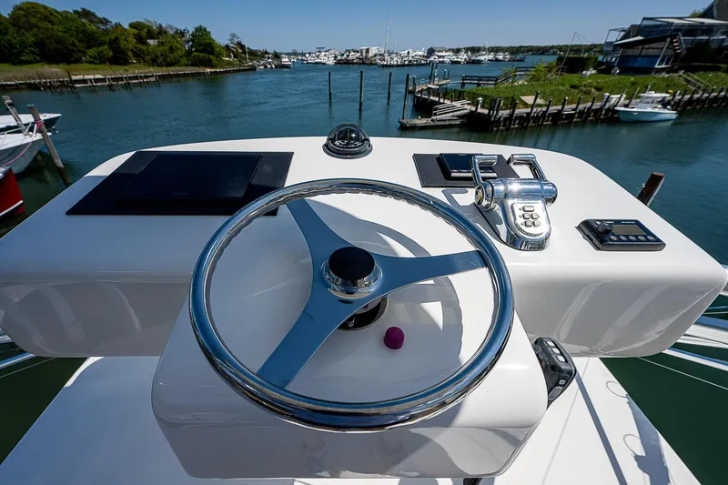 Slide: The Image of Steering wheel of 2012 Cabo 44 HTX yacht with marina view. - 31