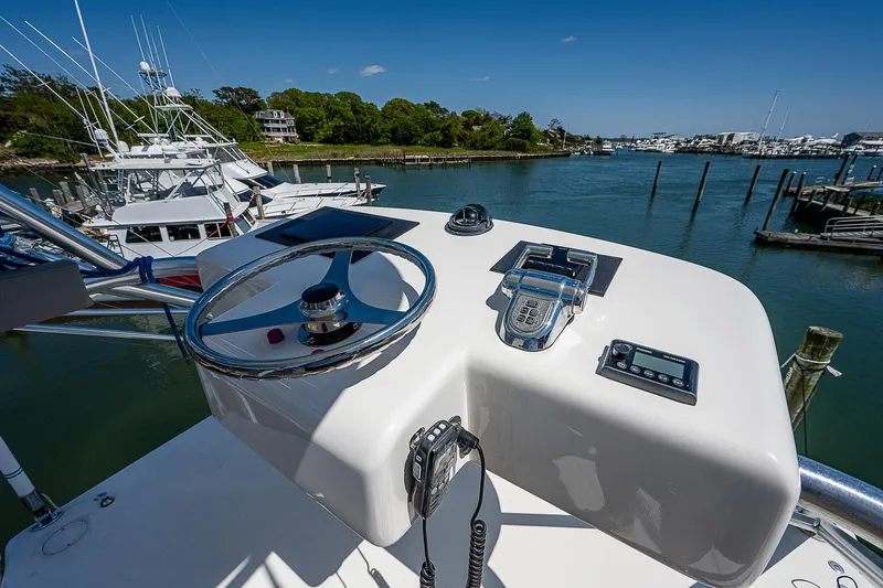 Slide: The Image of Helm of 2012 Cabo 44 HTX yacht docked in a scenic marina. - 32
