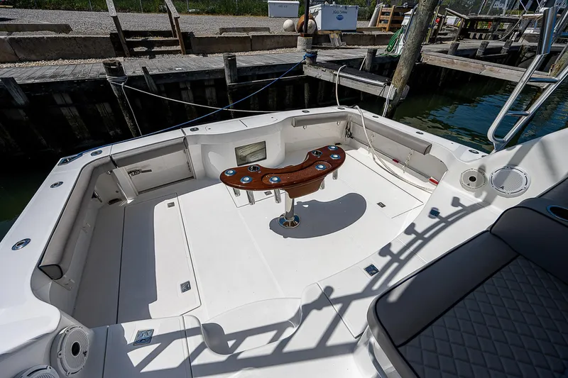 Slide: The Image of 2012 Cabo 44 HTX boat deck with fishing rod holders and seating area. - 37