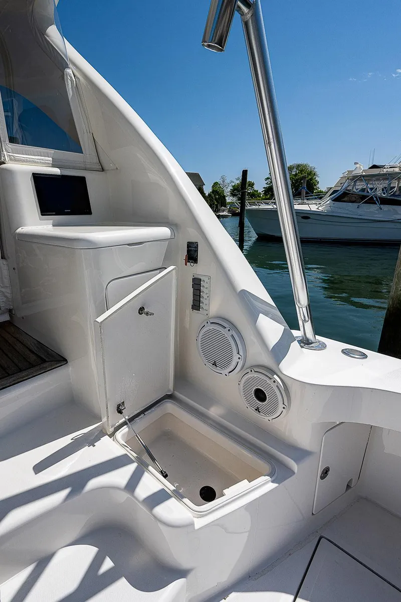 Slide: The Image of 2012 Cabo 44 HTX yacht interior with storage and speakers, docked by the water. - 42