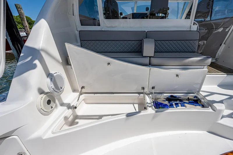 Slide: The Image of 2012 Cabo 44 HTX boat interior with open storage compartment and cushioned seating. - 44