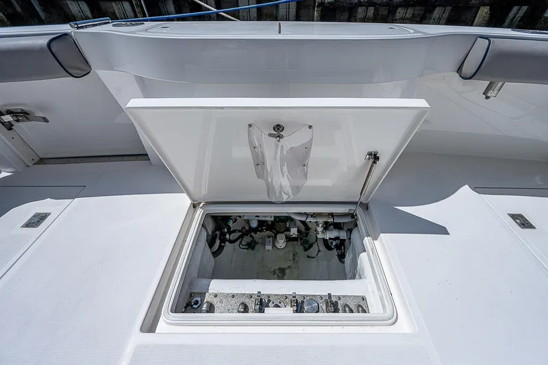 Slide: The Image of Open hatch on 2012 Cabo 44 HTX boat deck, revealing storage compartment. - 49