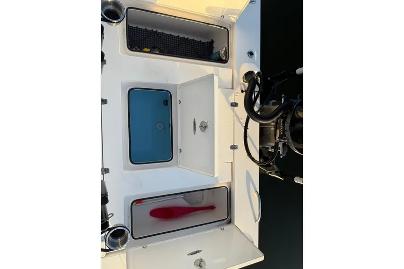 Slide: The Image of 2021 Hewes Redfisher 21 boat storage compartments and engine controls. - 11