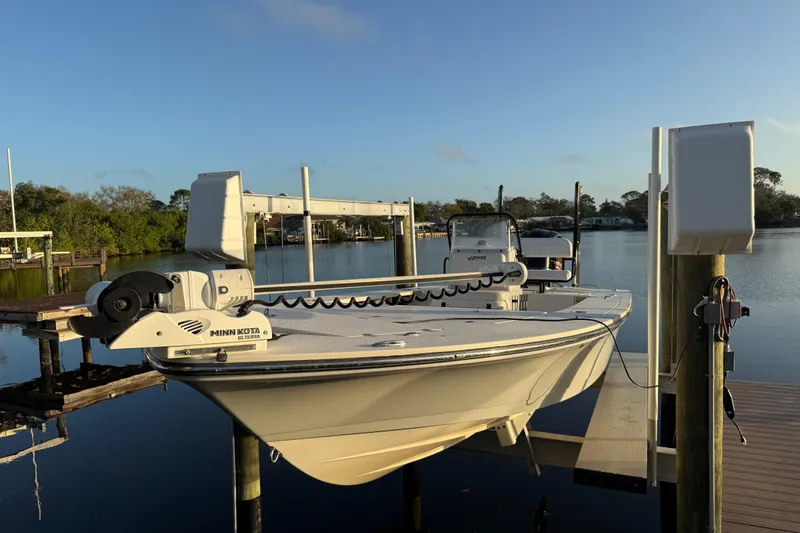 Slide: The Image of 2021 Hewes Redfisher 21 boat docked with Minn Kota motor, scenic waterfront view. - 18