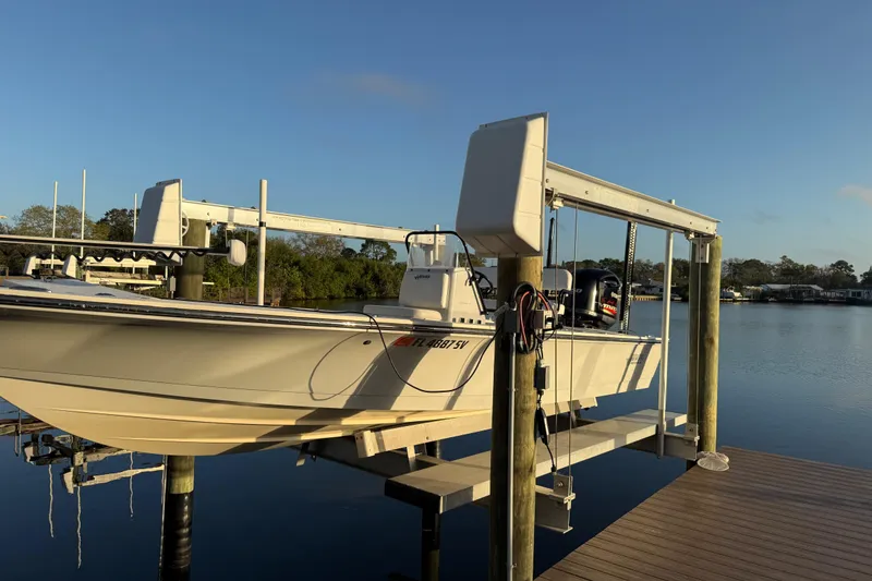 Slide: The Image of 2021 Hewes Redfisher 21 boat on lift at serene waterfront dock. - 19