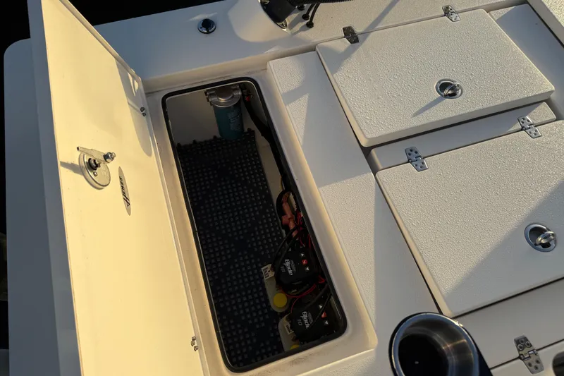 Slide: The Image of 2021 Hewes Redfisher 21 boat storage compartment with open hatch and visible wiring. - 9