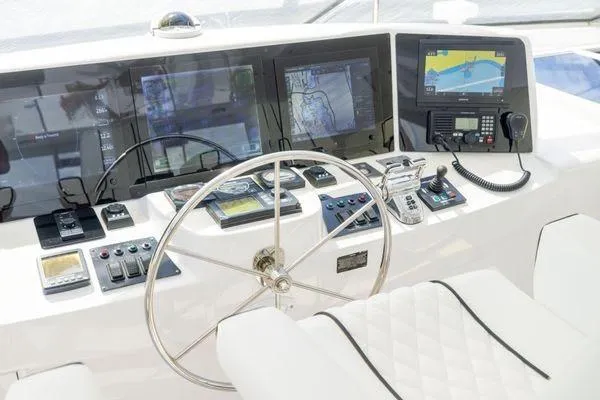 Slide: The Image of Control panel of a 2005 Hatteras 80 Motor Yacht with navigation instruments and steering wheel. - 52