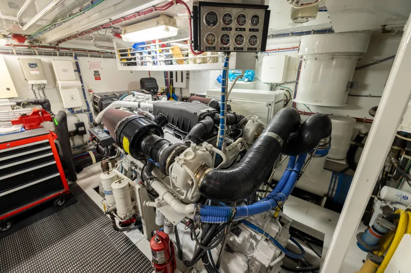 Slide: The Image of Engine room of 2005 Hatteras 80 Motor Yacht, featuring complex machinery and control panel. - 69