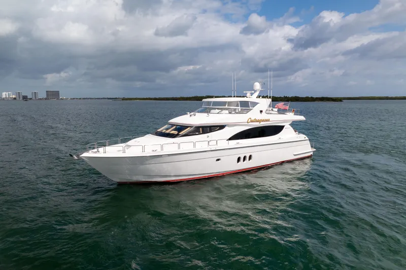 Slide: The Image of 2005 Hatteras 80 Motor Yacht cruising on open water under cloudy skies. - 70