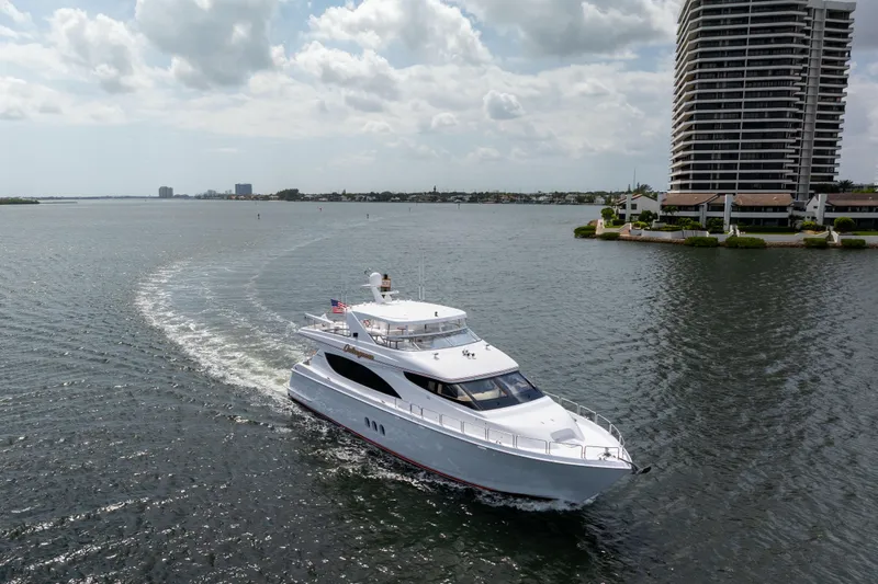 Slide: The Image of 2005 Hatteras 80 Motor Yacht cruising near waterfront buildings under cloudy sky. - 71