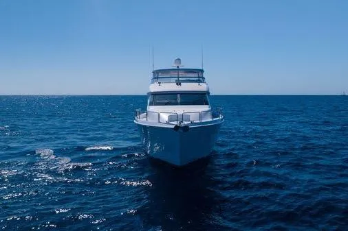 Slide: The Image of 2005 Hatteras 80 Motor Yacht cruising on open water under clear blue skies. - 9