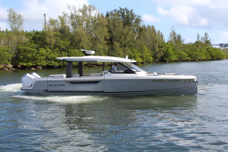 The Image of 2025 Saxdor 400 GTS luxury boat cruising on a scenic waterway. - 0