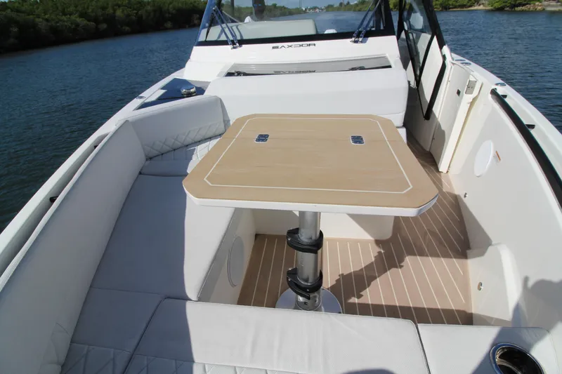 Slide: The Image of 2025 Saxdor 400 GTS boat interior with seating and table on calm water. - 13