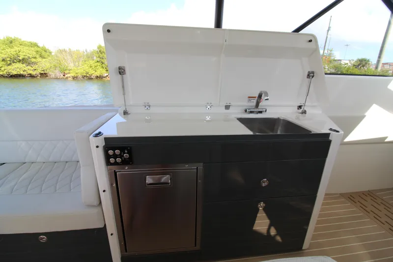 Slide: The Image of 2025 Saxdor 400 GTS yacht kitchenette with sink and storage, overlooking water. - 20