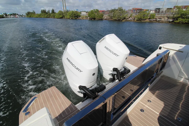 Slide: The Image of 2025 Saxdor 400 GTS with dual Mercury outboard engines cruising on a scenic waterway. - 30