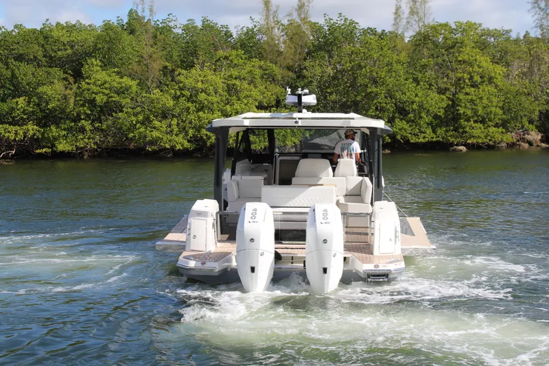 Slide: The Image of 2025 Saxdor 400 GTS boat cruising on a scenic waterway with lush greenery. - 40