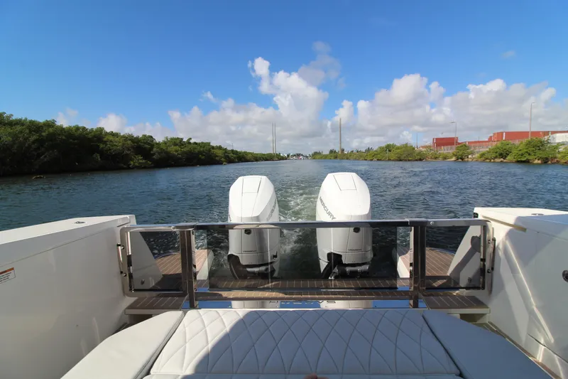 Slide: The Image of 2025 Saxdor 400 GTS boat with dual engines cruising on a scenic waterway. - 9