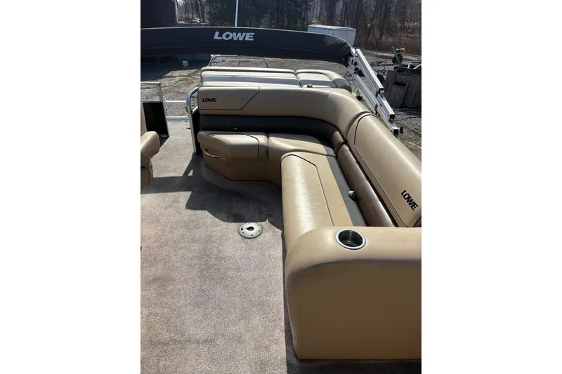 Slide: The Image of 2018 Lowe SS 210 pontoon boat with tan seating and cup holders. - 11