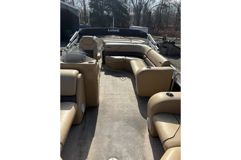 Slide: The Image of 2018 Lowe SS 210 pontoon boat with tan seating and spacious deck. - 12