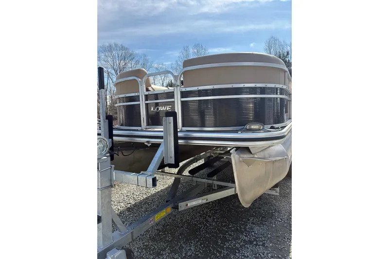 Slide: The Image of 2018 Lowe SS 210 pontoon boat on trailer, parked outdoors. - 3