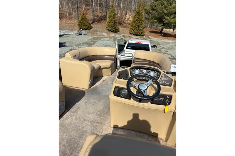 Slide: The Image of 2018 Lowe SS 210 pontoon boat interior with steering wheel and seating. - 7