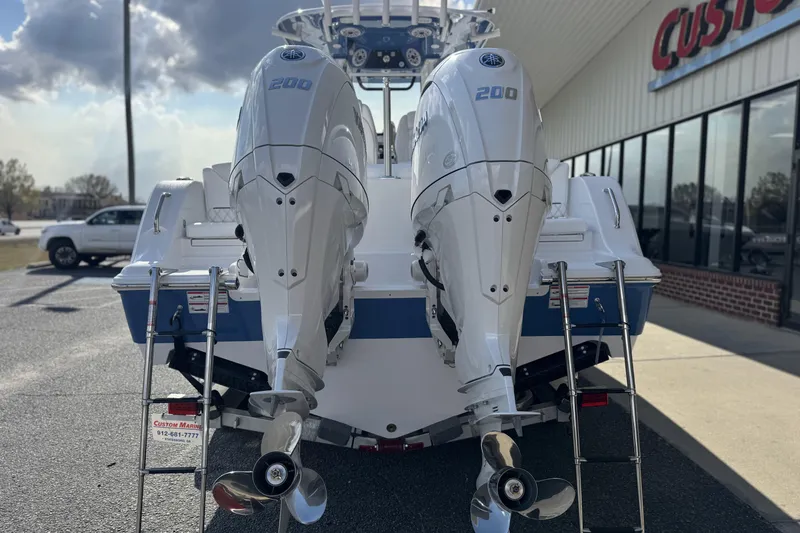 Slide: The Image of 2026 Sportsman Heritage 261 Center Console with twin 200 horsepower engines, parked outside. - 10