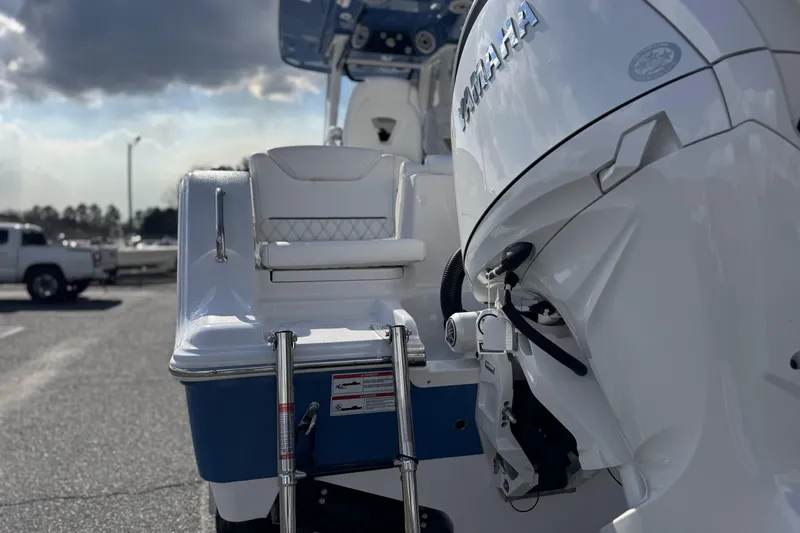 Slide: The Image of 2026 Sportsman Heritage 261 Center Console boat with Yamaha engine, docked under cloudy sky. - 11