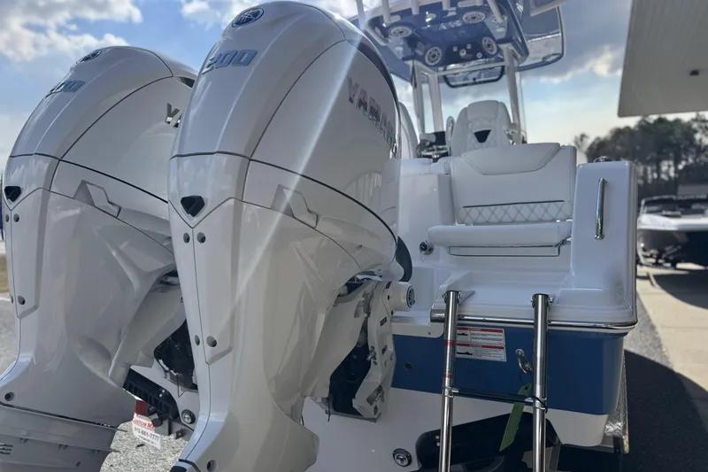Slide: The Image of 2026 Sportsman Heritage 261 Center Console with dual outboard engines, docked under a cloudy sky. - 12