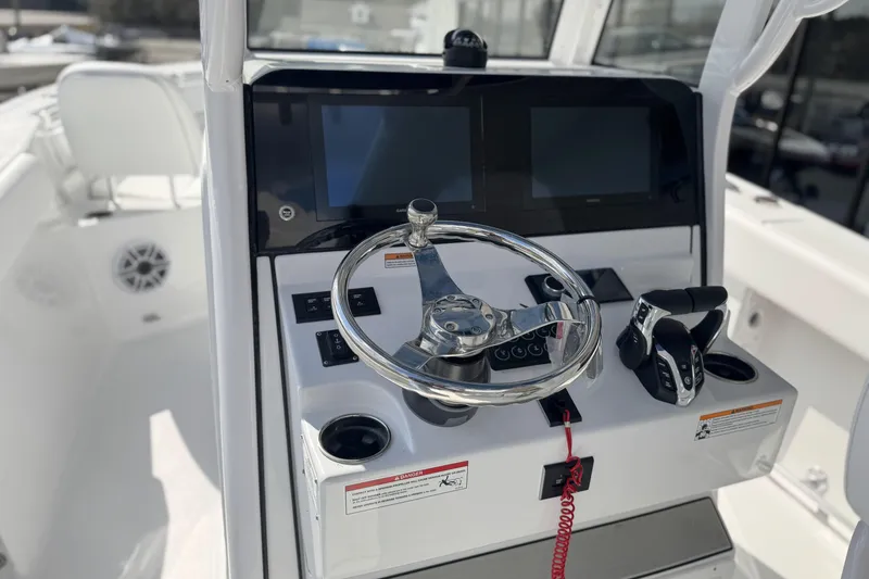 Slide: The Image of 2026 Sportsman Heritage 261 Center Console boat dashboard with steering wheel and controls. - 19