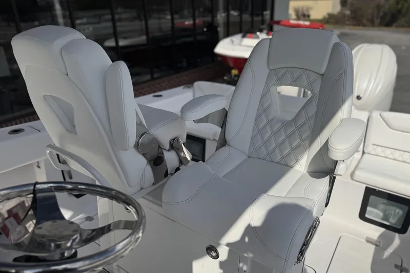 Slide: The Image of 2026 Sportsman Heritage 261 Center Console boat with luxurious white seating and steering wheel. - 20