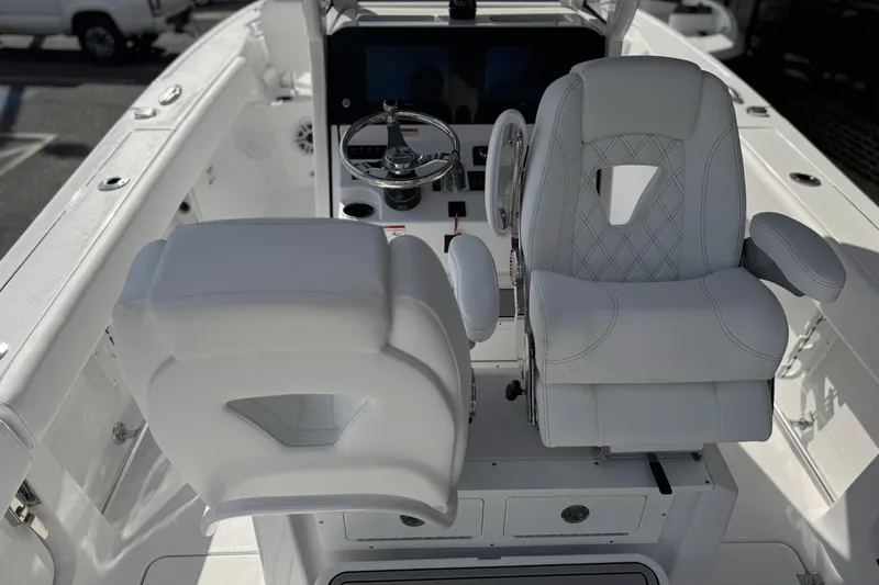 Slide: The Image of 2026 Sportsman Heritage 261 Center Console boat interior with white seating and steering wheel. - 21