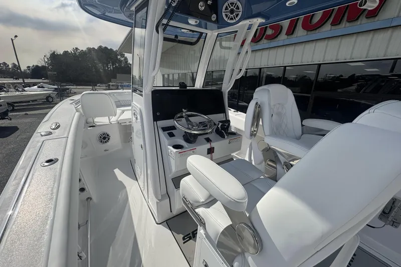 Slide: The Image of 2026 Sportsman Heritage 261 Center Console boat interior with white seating and modern controls. - 22
