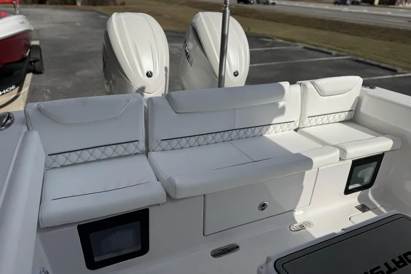 Slide: The Image of 2026 Sportsman Heritage 261 Center Console boat with white cushioned seating and dual engines. - 25