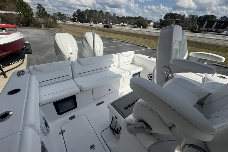 Slide: The Image of 2026 Sportsman Heritage 261 Center Console boat interior with white seating and dual engines. - 26