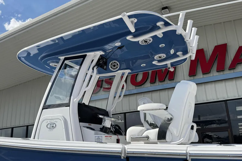 Slide: The Image of 2026 Sportsman Heritage 261 Center Console boat with T-top and seating, displayed outdoors. - 3