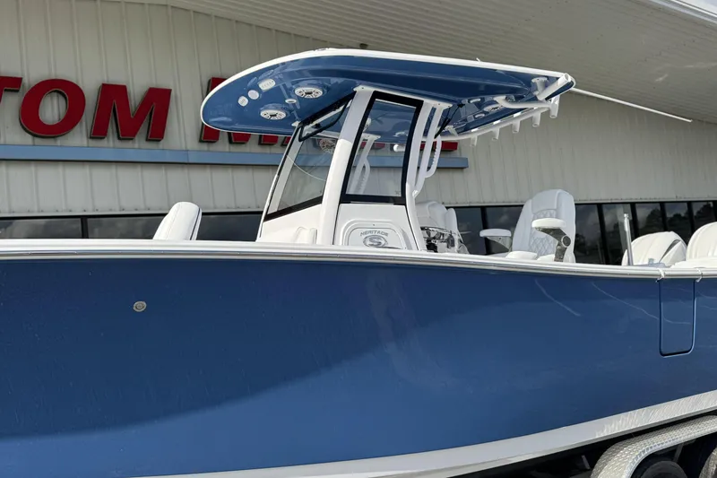 Slide: The Image of 2026 Sportsman Heritage 261 Center Console boat with blue hull and T-top. - 8