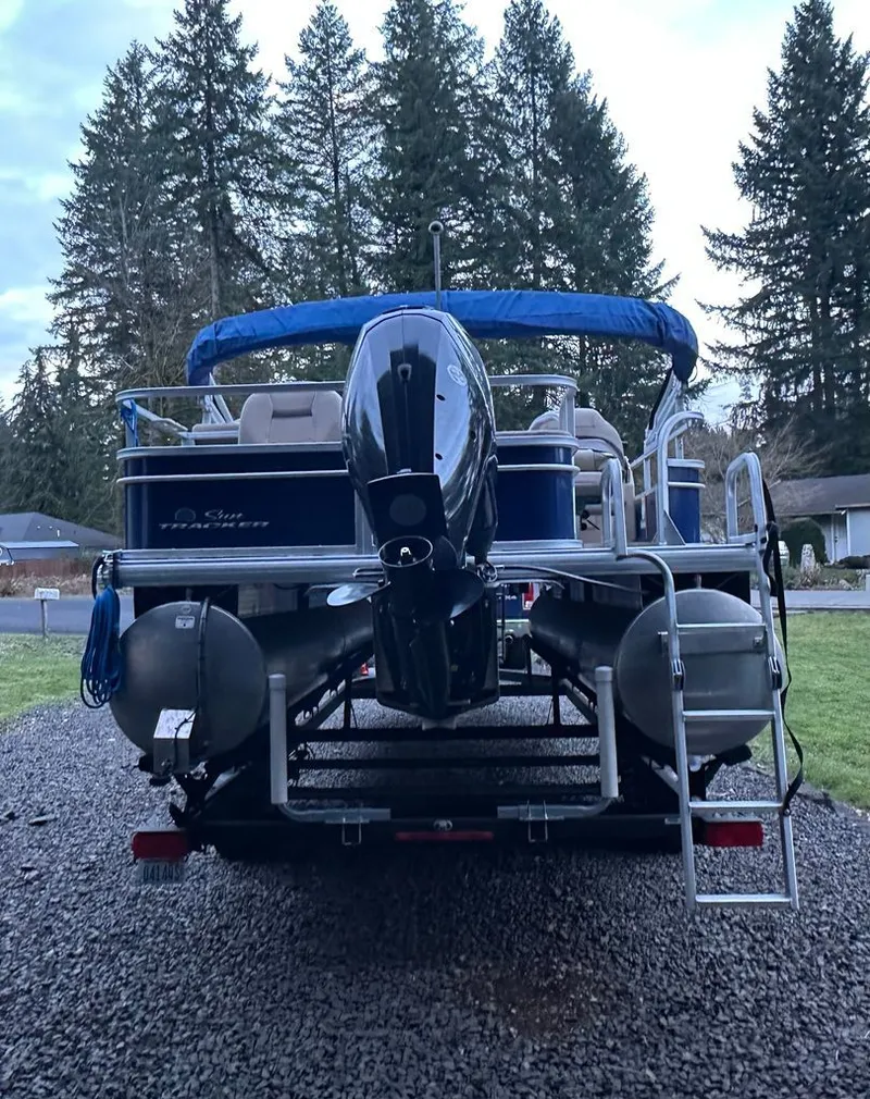 Slide: The Image of 2017 Sun Tracker FISHIN BARGE on trailer, surrounded by trees. - 3