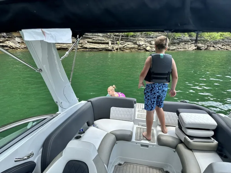 Slide: The Image of Children on a 2022 Crownline 265 SS boat in the water. - 8