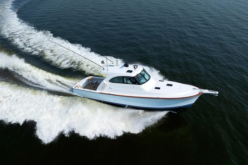 Slide: The Image of 2023 Henriques 42 Express Hardtop cruising on open water, creating a dynamic wake. - 2