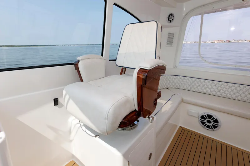 Slide: The Image of Luxury seating on 2023 Henriques 42 Express Hardtop yacht interior, overlooking serene waters. - 38