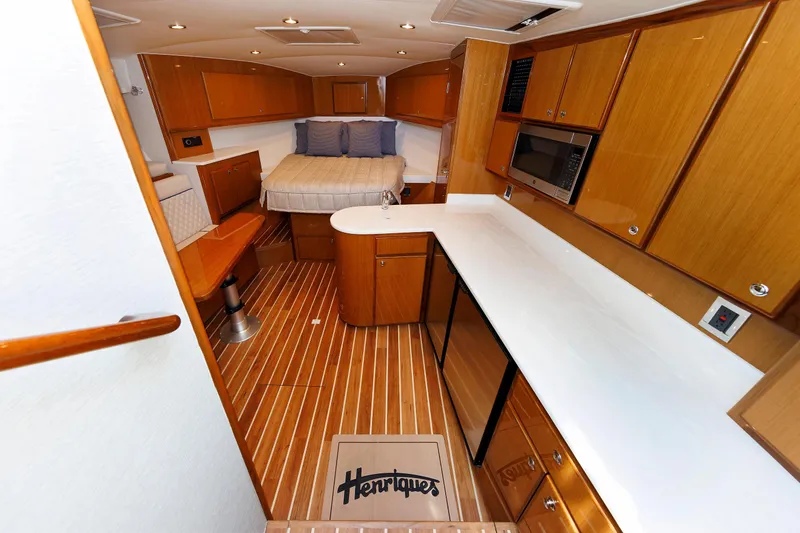 Slide: The Image of Interior of 2023 Henriques 42 Express Hardtop with wood cabinetry and modern amenities. - 45